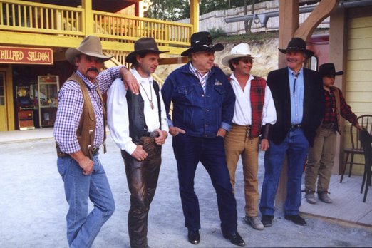Der Plan, eine Westernstadt zu erschaffen Sieben Personen in Cowboykleidung