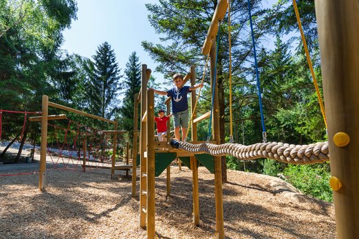 Der "Adventure Trail" der Westernstadt Junge balanciert über dickes Seil in einem Niederseilgarten